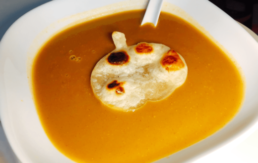 Bowl of Butternut squash soup with a pumpkin shaped tortilla bread on top