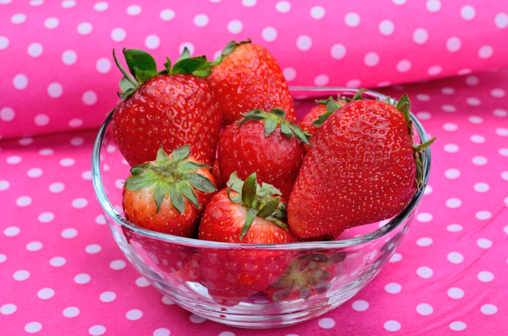 strawberries in bowl on pink background